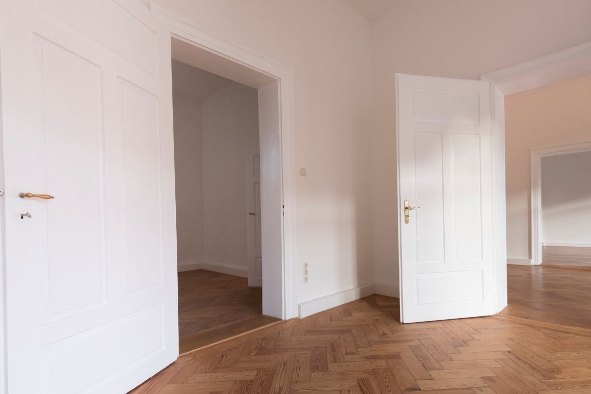 Leerer Raum mit Parkett und offenen Türen
